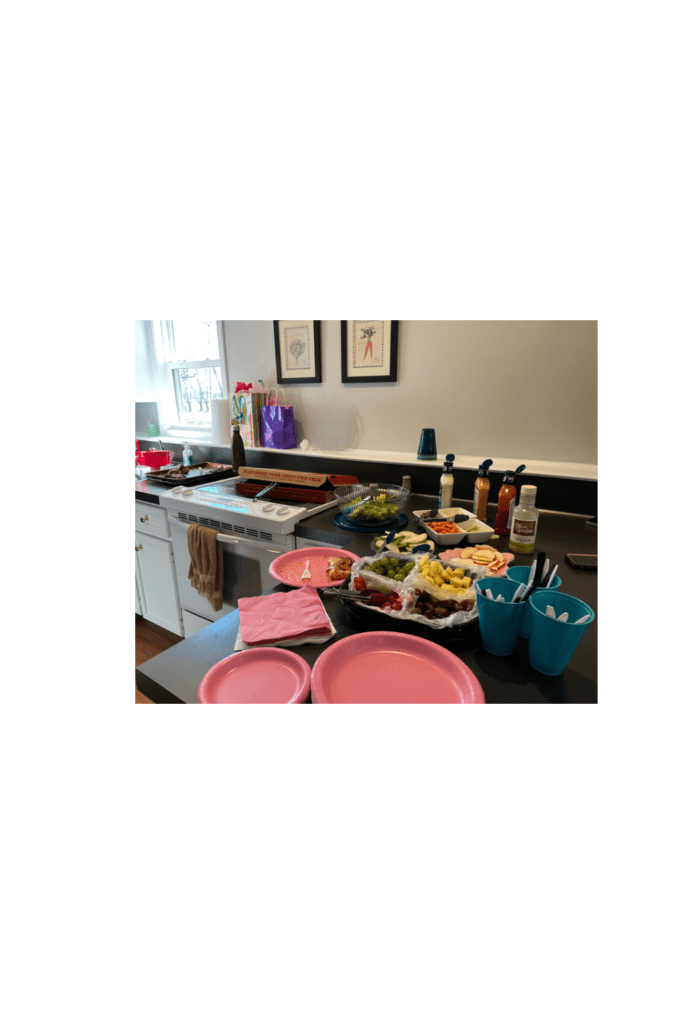food on counter with pink plates and napkins.