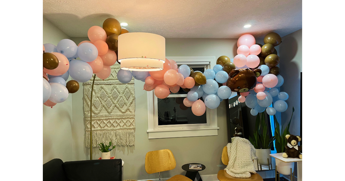 Balloon arch with blue, pink and brown balloons. Two chars and two lamps.