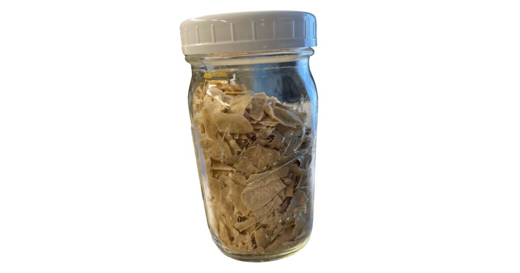 Dried sourdough starter flakes in a ball mason jar with a lid