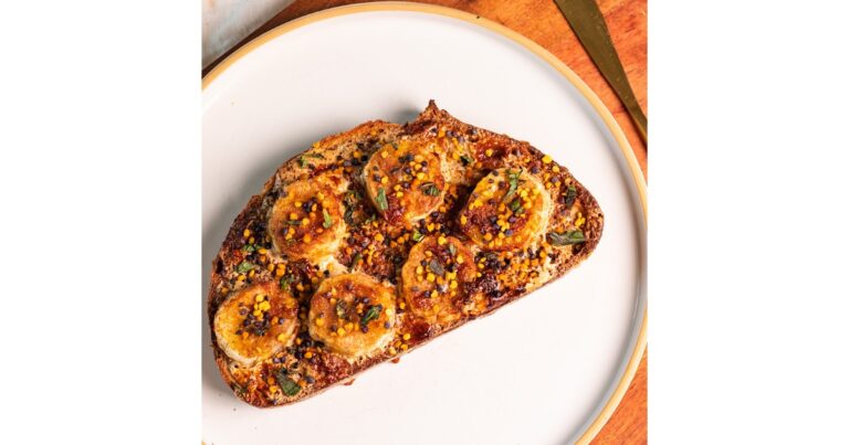 Toast with bananas, tahini and spices on top of a white plate.