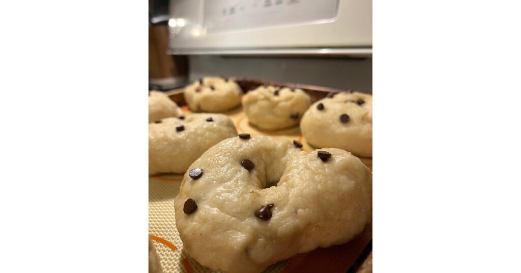 Six Sourdough Chocolate Chip Bagels on a sheet pan before baked in oven