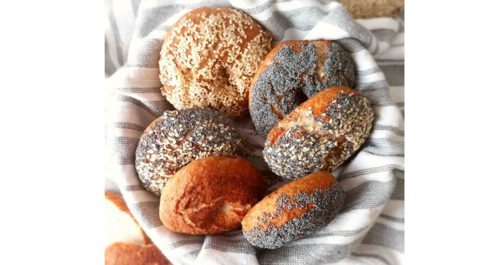6 Bagels with spices on top in a bread basket