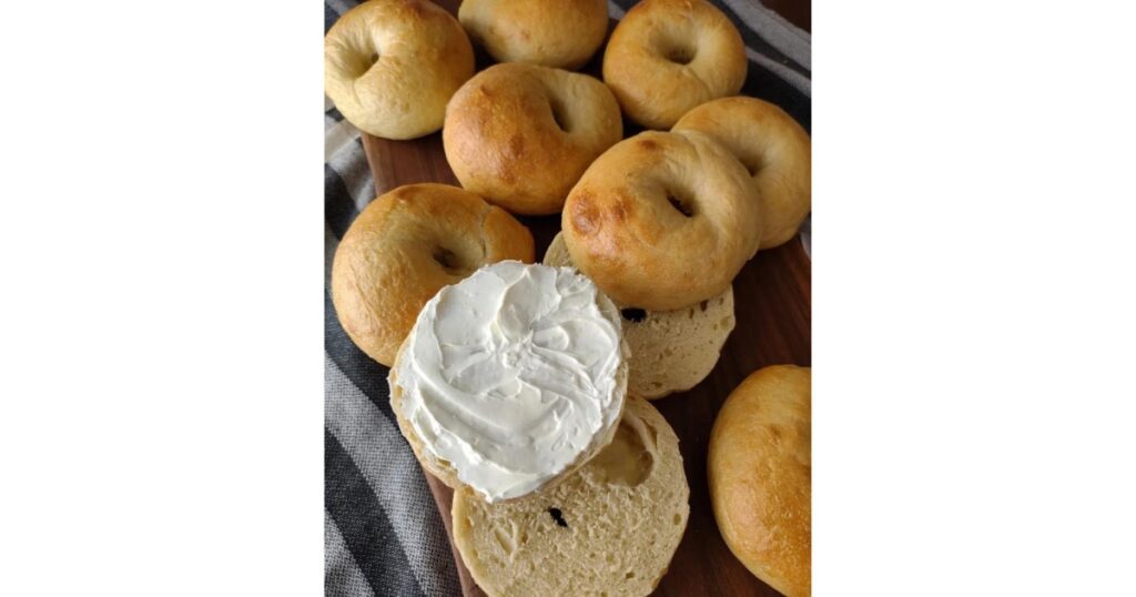 Bagel stack with one cut open on top and slathered with cream cheese