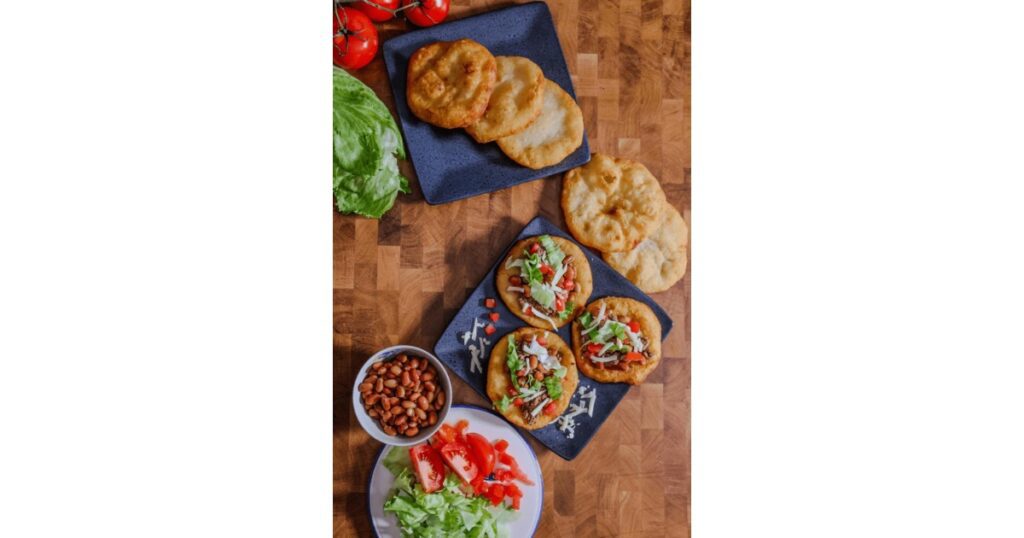 Fry bread topped with tomato, lettuce and beans.