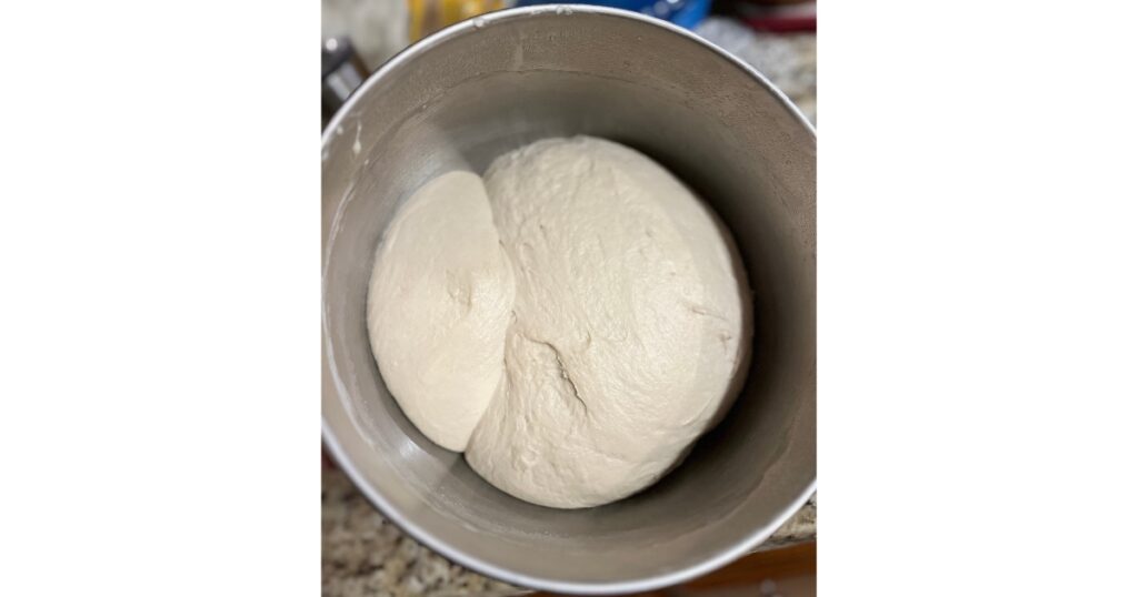 Proofed dough in mixing bowl.