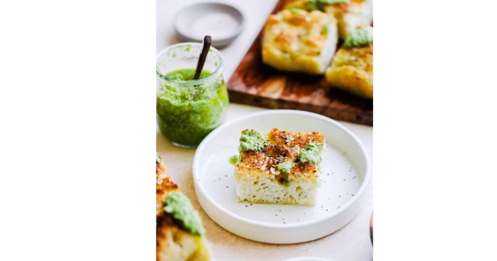 black pepper sourdough focaccia in front of pesto