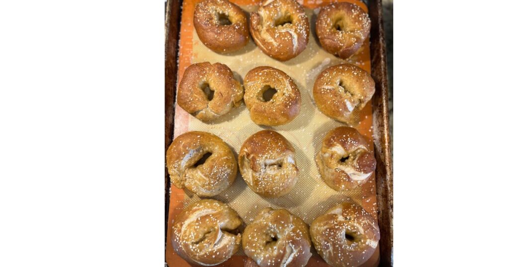 Cooked tray of pretzel bagels on a sheet pan