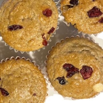 close up of muffins with white chocolate and dried cranberries on top