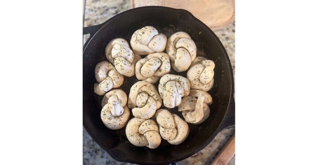 garlic knots in cast iron skillet in a circle shape