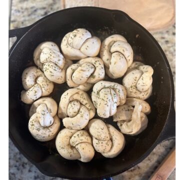 garlic knots in cast iron skillet in a circle shape