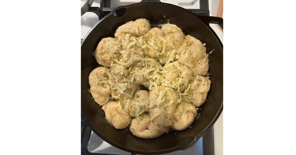 garlic butter in a cast iron skillet with cheese on top