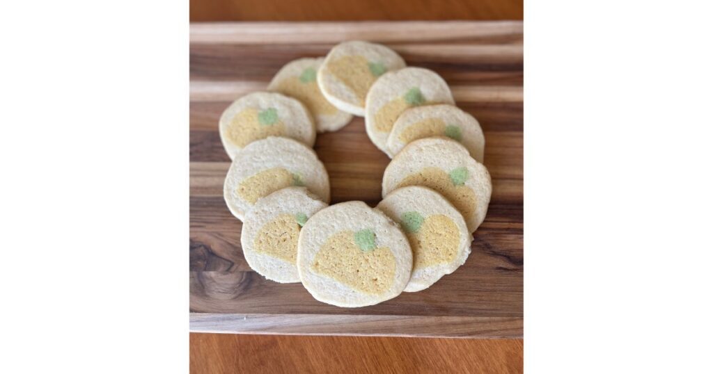 pumpkin cookies in a circle on a wooden cutting board