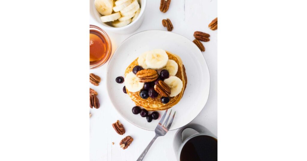 overhead shot of pancakes with blueberries, bananas and pecans.