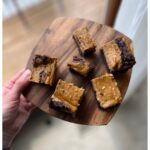 slices of pumpkin cheesecake sourdough brownies on a wooden cutting board