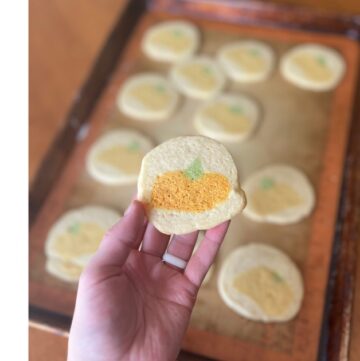 sugar cookies with pumpkin design on a baking sheet