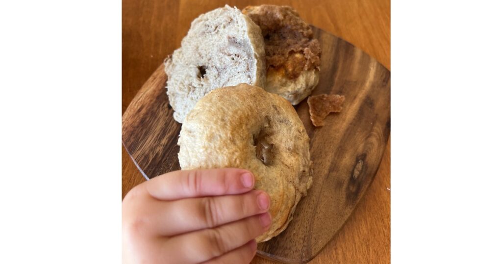 toddler taking a bagel off counter