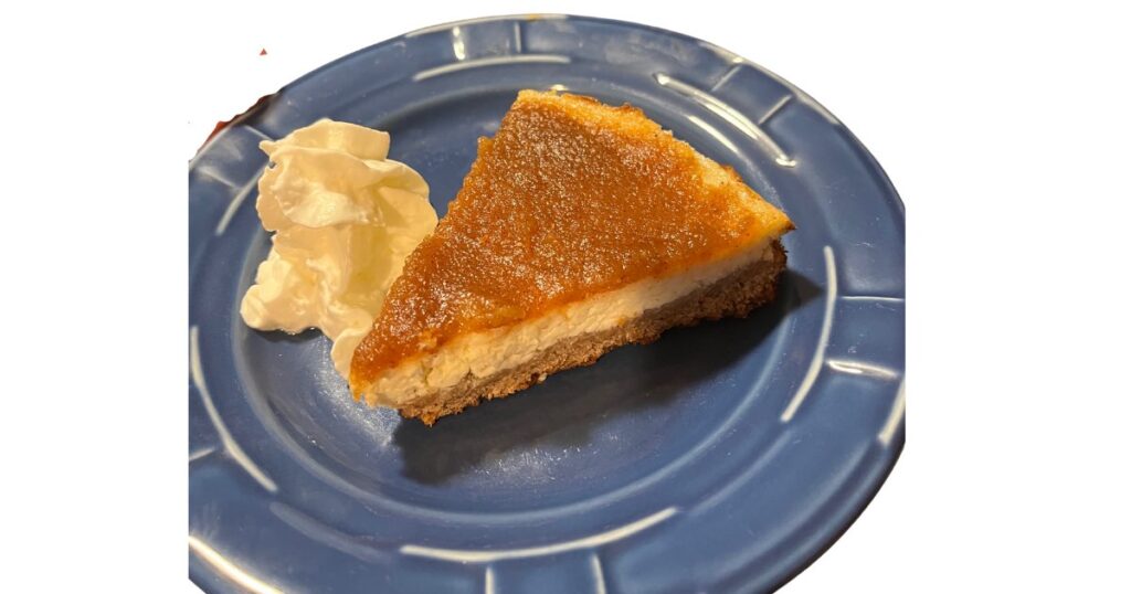 apple butter cheesecake with whipped cream and on a blue plate