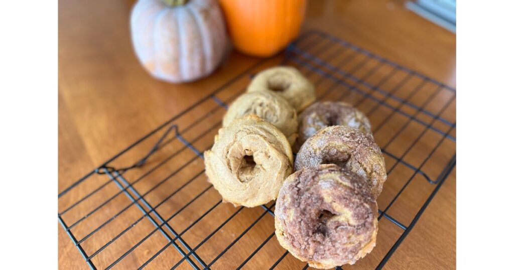 six pumpkin donuts cooling on rack