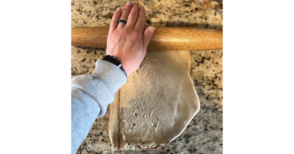 hand rolling cinnamon rolls with a rolling pin