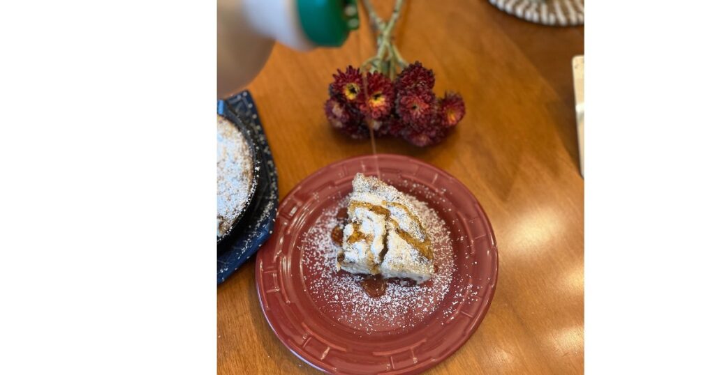 slice of pancake on a red plate with maple syrup poured on top