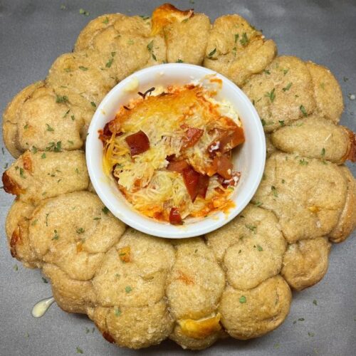 sourdough cheese bread with smoked pizza dip in middle on a baking sheet