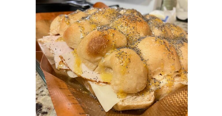 pan of hawaiian roll sliders made with lunch meat.